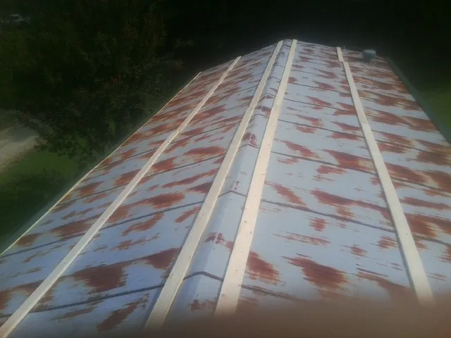 Rusted metal roof panels with new wood purlins before replacement — Storm Damage Roof Repair in Picayune by Roofing Brothers